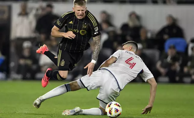 CORRECTS TO SECOND HALF FROM FIRST HALF - Los Angeles FC midfielder Mateusz Bogusz, left, gets tripped by Vancouver Whitecaps defender Ranko Veselinović (4) during the second half of the first match of an MLS Cup playoffs opening round in Los Angeles, Sunday, Oct. 27, 2024. (AP Photo/Alex Gallardo)