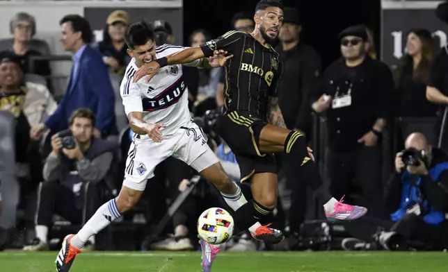 CORRECTS TO SECOND HALF FROM FIRST HALF - Vancouver Whitecaps defender Mathías Laborda, left, collides with Los Angeles FC forward Denis Bouanga, right, during the second half of the first match of an MLS Cup playoffs opening round in Los Angeles, Sunday, Oct. 27, 2024. (AP Photo/Alex Gallardo)