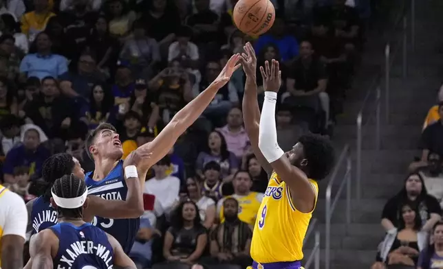 CORRECTS TO PALM DESERT, CALIF., NOT LOS ANGELES - Los Angeles Lakers guard Bronny James, right, shoots as Minnesota Timberwolves center Luka Garza defends during the first half of a preseason NBA basketball game, Friday, Oct. 4, 2024, in Palm Desert, Calif. (AP Photo/Mark J. Terrill)