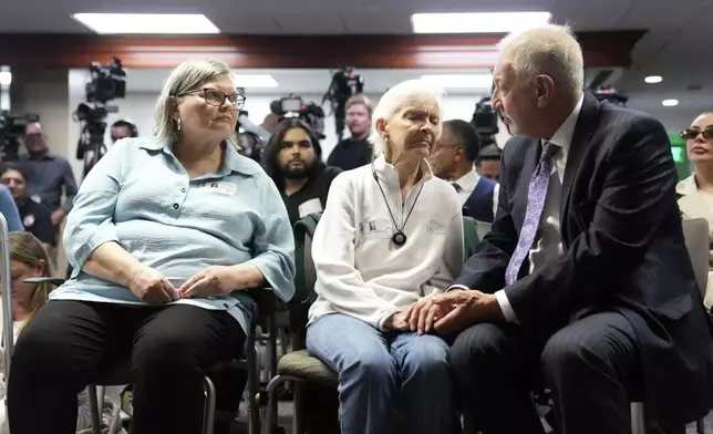 Kitty Menendez's sister, Joan Andersen VanderMolen, center is greeted by Defense Attorney Mark Geragos as Diane Hernandez niece of Kitty Menendez, left, looks on prior to a news conference being held by Los Angeles County District Attorney George Gascon at the Hall of Justice on Thursday, Oct. 24, 2024, in Los Angeles. (AP Photo/Eric Thayer)