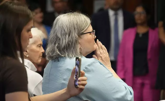 Diane Hernandez, Niece of Kitty Menendez, holds her hands as Los Angeles County District Attorney George Gascon announces he will ask a judge to resentence Erik and Lyle Menendez, two brothers serving life sentences for killing their parents, at a news conference at the Hall of Justice in Los Angeles on Thursday, Oct. 24, 2024, in Los Angeles. (AP Photo/Damian Dovarganes)