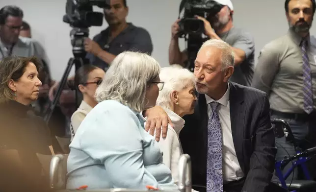 Kitty Menendez's sister, Joan Andersen VanderMolen, center, is greeted by Defense Attorney Mark Geragos, right, as Diane Hernandez niece of Kitty Menendez, left, looks on prior to a news conference being held by Los Angeles County District Attorney George Gascon at the Hall of Justice on Thursday, Oct. 24, 2024, in Los Angeles (AP Photo/Damian Dovarganes)