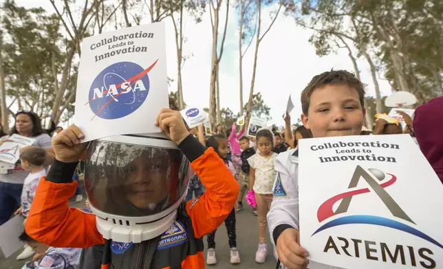 Santiago STEAM Magnet Elementary School students wearing space themed clothing attend a ceremony to plant a small Giant Sequoia tree from NASA's Artemis I Mission's tree seeds that traveled around the moon twice, after the school was honored in the spring of 2024 to become NASA Moon Tree Stewards in Lake Forest, Calif., on Monday, Oct. 14, 2024. (AP Photo/Damian Dovarganes)