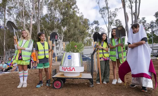 Students at Santiago STEAM Magnet Elementary School participate at a ceremony to plant a small Giant Sequoia tree from NASA's Artemis I Mission's tree seeds that traveled around the moon twice, after the school was honored in the spring of 2024 to become NASA Moon Tree Stewards in Lake Forest, Calif., on Monday, Oct. 14, 2024. (AP Photo/Damian Dovarganes)