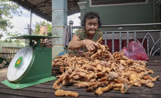 Ry Lean, 73, a crocodile farmer sorts and stacks crocodile jerky for delivery, in Siem Reap Province, on Aug. 9, 2024. (AP Photo/Anton L. Delgado)