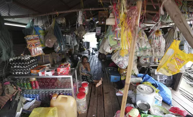 A local vendor sits at her grocery store at a floating village by the Tonle Sap in Kampong Chhnang province, Cambodia, Thursday, Aug. 1, 2024, (AP Photo/Heng Sinith)