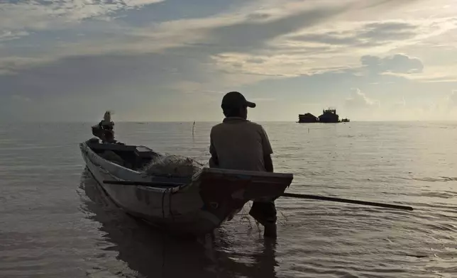 A fisherman sits on a boat in the Tonle Sap lake, Siem Reap, Cambodia, Friday, Aug. 2, 2024. (AP Photo/Aniruddha Ghosal)