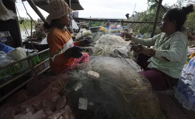 Locals fix their fishing nets at a floating village by the Tonle Sap in Kampong Chhnang province, Cambodia, Thursday, Aug. 1, 2024, (AP Photo/Heng Sinith)