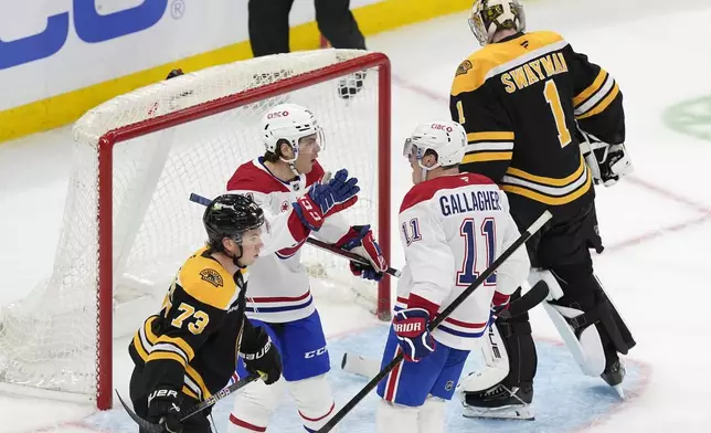 Montreal Canadiens' Brendan Gallagher (11) celebrates after his goal against Boston Bruins' Jeremy Swayman (1) and Charlie McAvoy (73) with teammate Jake Evans (71) during the third period of an NHL hockey game, Thursday, Oct. 10, 2024, in Boston. (AP Photo/Michael Dwyer)