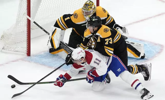 Boston Bruins' Charlie McAvoy (73) defends agasint Montreal Canadiens' Brendan Gallagher (11) in front of Jeremy Swayman (1) during the third period of an NHL hockey game, Thursday, Oct. 10, 2024, in Boston. (AP Photo/Michael Dwyer)