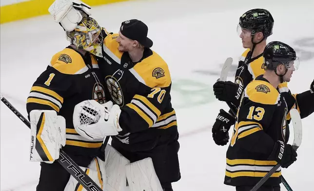 Boston Bruins' Jeremy Swayman (1) celebrates with Joonas Korpisalo (70) beside Morgan Geekie (39) and Charlie Coyle (13) after defeating the Montreal Canadiens during an NHL hockey game, Thursday, Oct. 10, 2024, in Boston. (AP Photo/Michael Dwyer)