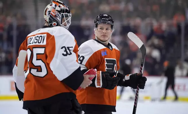 Philadelphia Flyers' Matvei Michkov, right, and Aleksei Kolosov talk during the first period of an NHL hockey game against the Montreal Canadiens, Sunday, Oct. 27, 2024, in Philadelphia. (AP Photo/Matt Slocum)