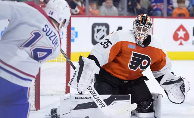 Philadelphia Flyers' Aleksei Kolosov, right, blocks a shot by Montreal Canadiens' Nick Suzuki during the first period of an NHL hockey game, Sunday, Oct. 27, 2024, in Philadelphia. (AP Photo/Matt Slocum)