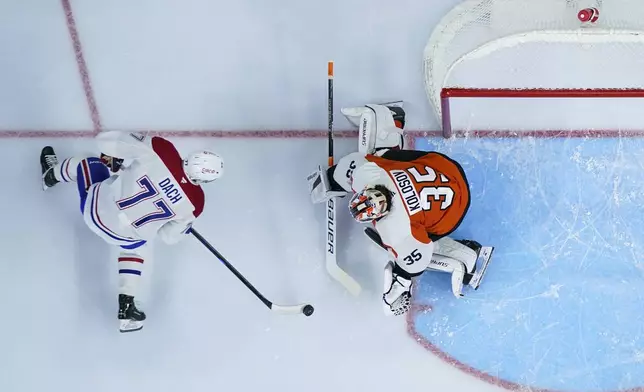 Montreal Canadiens' Kirby Dach, left, tries to get a shot past Philadelphia Flyers' Aleksei Kolosov during the first period of an NHL hockey game, Sunday, Oct. 27, 2024, in Philadelphia. (AP Photo/Matt Slocum)