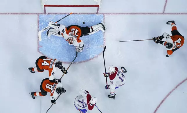 Montreal Canadiens' Nick Suzuki (14) scores against Philadelphia Flyers' Aleksei Kolosov (35) during the first period of an NHL hockey game, Sunday, Oct. 27, 2024, in Philadelphia. (AP Photo/Matt Slocum)