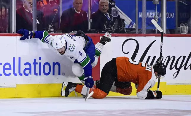 Vancouver Canucks' Conor Garland, left, and Philadelphia Flyers' Egor Zamula collide along the boards during the third period of an NHL hockey game, Saturday, Oct. 19, 2024, in Philadelphia. (AP Photo/Derik Hamilton)