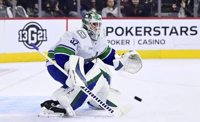 Vancouver Canucks goaltender Kevin Lankinen watches a loose puck during the second period of an NHL hockey game against the Philadelphia Flyers, Saturday, Oct. 19, 2024, in Philadelphia. (AP Photo/Derik Hamilton)