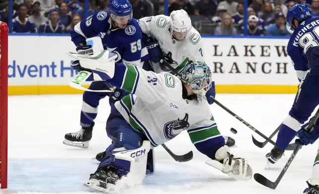 Vancouver Canucks goaltender Arturs Silovs (31) stops a shot by Tampa Bay Lightning right wing Nikita Kucherov (86) during the second period of an NHL hockey game Tuesday, Oct. 15, 2024, in Tampa, Fla. Vancouver Canucks' Carson Soucy (7) keeps Tampa Bay Lightning's Jake Guentzel from a rebound. (AP Photo/Chris O'Meara)