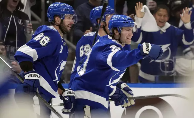 Tampa Bay Lightning center Brayden Point (21) celebrates his goal against the Vancouver Canucks with right wing Nikita Kucherov (86) and center Jake Guentzel (59) during the second period of an NHL hockey game Tuesday, Oct. 15, 2024, in Tampa, Fla. (AP Photo/Chris O'Meara)