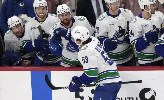 Vancouver Canucks center Teddy Blueger (53) is congratulated by teammates after he scored during the first period of an NHL hockey game against the Florida Panthers, Thursday, Oct. 17, 2024, in Sunrise, Fla. (AP Photo/Wilfredo Lee)