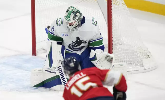 Florida Panthers center Anton Lundell (15) shoots and scores against Vancouver Canucks goaltender Kevin Lankinen (32) during the second period of an NHL hockey game, Thursday, Oct. 17, 2024, in Sunrise, Fla. (AP Photo/Wilfredo Lee)