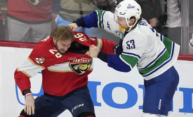 Vancouver Canucks center Teddy Blueger (53) and Florida Panthers defenseman Uvis Balinskis (26) fight during the second period of an NHL hockey game, Thursday, Oct. 17, 2024, in Sunrise, Fla. (AP Photo/Wilfredo Lee)