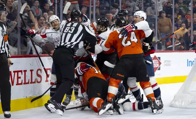 A scrum happens after the whistle to end the second period of an NHL hockey game between the Washington Capitals and the Philadelphia Flyers, Tuesday, Oct. 22, 2024, in Philadelphia. (AP Photo/Chris Szagola)