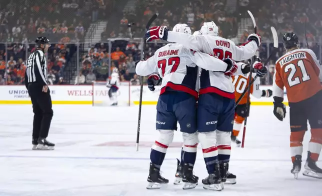 Washington Capitals' Nic Dowd, center, celebrates his goal with teammates during the first period of an NHL hockey game against the Philadelphia Flyers, Tuesday, Oct. 22, 2024, in Philadelphia. (AP Photo/Chris Szagola)