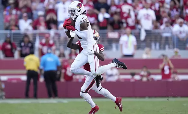 Arizona Cardinals wide receiver Marvin Harrison Jr., top, catches a pass in front of San Francisco 49ers cornerback Isaac Yiadom during the second half of an NFL football game in Santa Clara, Calif., Sunday, Oct. 6, 2024. (AP Photo/Godofredo A. Vásquez)