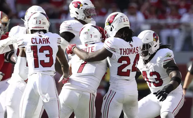 Arizona Cardinals linebacker Kyzir White, middle, is congratulated by teammates after intercepting a pass against the San Francisco 49ers during the second half of an NFL football game in Santa Clara, Calif., Sunday, Oct. 6, 2024. (AP Photo/Jed Jacobsohn)