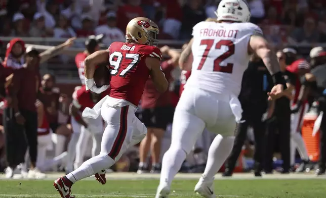 San Francisco 49ers defensive end Nick Bosa (97) returns an interception in front of Arizona Cardinals guard Hjalte Froholdt (72) during the first half of an NFL football game in Santa Clara, Calif., Sunday, Oct. 6, 2024. (AP Photo/Jed Jacobsohn)