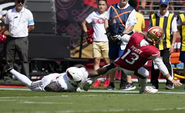 Arizona Cardinals linebacker Krys Barnes, left, tackles San Francisco 49ers quarterback Brock Purdy (13) during the first half of an NFL football game in Santa Clara, Calif., Sunday, Oct. 6, 2024. (AP Photo/Godofredo A. Vásquez)