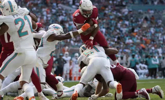 Miami Dolphins linebackers Tyus Bowser (51) and Jordyn Brooks (20) stop Arizona Cardinals running back James Conner's (6) attempt to score a two-point conversion during the second half of an NFL football game against the Miami Dolphins, Sunday, Oct. 27, 2024, in Miami Gardens, Fla. (AP Photo/Lynne Sladky)