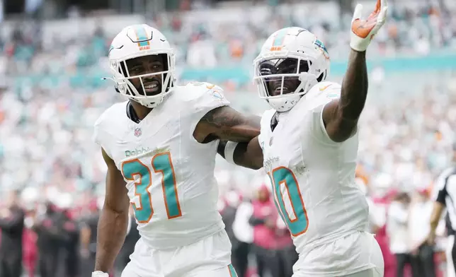 Miami Dolphins running back Raheem Mostert (31) celebrates his touchdown with wide receiver Tyreek Hill (10) during the first half of an NFL football game against the Arizona Cardinals, Sunday, Oct. 27, 2024, in Miami Gardens, Fla. (AP Photo/Lynne Sladky)