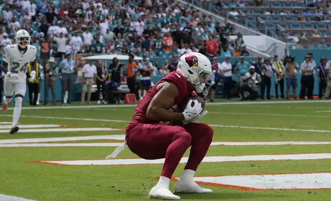 Arizona Cardinals wide receiver Michael Wilson (14) grabs a pass in the enzone for a touchdown during the first half of an NFL football game against the Miami Dolphins, Sunday, Oct. 27, 2024, in Miami Gardens, Fla. (AP Photo/Lynne Sladky)