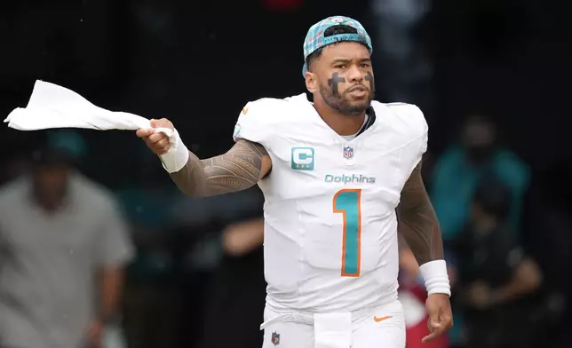 Miami Dolphins quarterback Tua Tagovailoa (1) enter the field before the first half of an NFL football game against the Arizona Cardinals, Sunday, Oct. 27, 2024, in Miami Gardens, Fla. (AP Photo/Rebecca Blackwell)