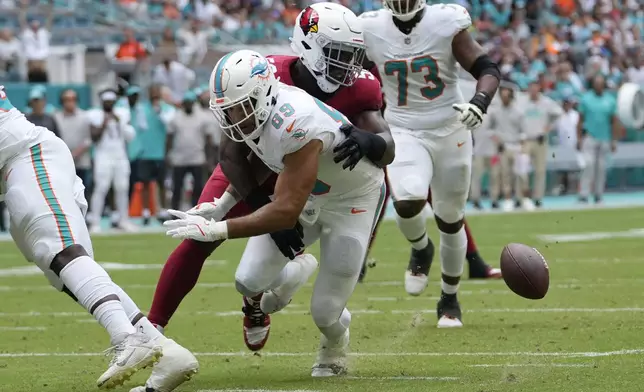 Miami Dolphins tight end Julian Hill (89) fumbles the ball on a a tackle by Arizona Cardinals linebacker Victor Dimukeje (52) during the first half of an NFL football game, Sunday, Oct. 27, 2024, in Miami Gardens, Fla. (AP Photo/Lynne Sladky)