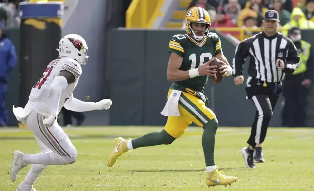 Green Bay Packers quarterback Jordan Love (10) is chased by Arizona Cardinals linebacker Krys Barnes (51) during the second half of an NFL football game, Sunday, Oct. 13, 2024, in Green Bay. (AP Photo/Mike Roemer)