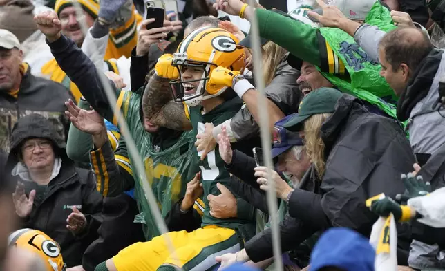 Green Bay Packers wide receiver Christian Watson celebrates with fans after his 44-yard reception for a touchdown during the first half of an NFL football game against the Arizona Cardinals, Sunday, Oct. 13, 2024, in Green Bay. (AP Photo/Morry Gash)