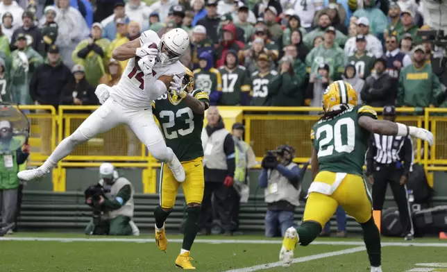 Arizona Cardinals wide receiver Michael Wilson (14), defended by Green Bay Packers cornerback Jaire Alexander (23), catches an 18-yard pass for a touchdown during the first half of an NFL football game, Sunday, Oct. 13, 2024, in Green Bay. (AP Photo/Matt Ludtke)