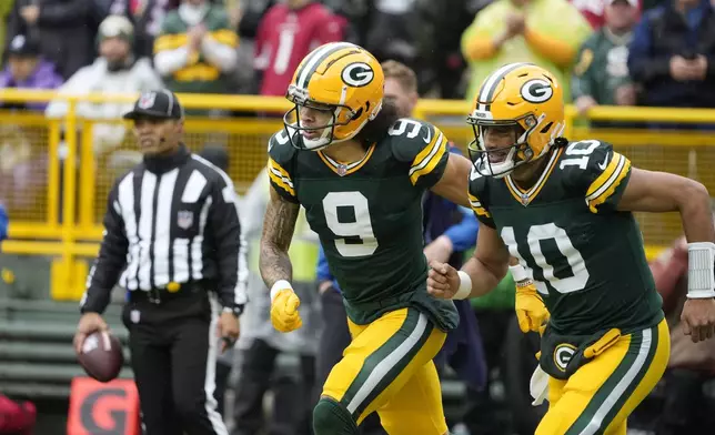 Green Bay Packers wide receiver Christian Watson (9) and quarterback Jordan Love (10) run to the bench after Watson's 44-yard reception for a touchdown during the first half of an NFL football game against the Arizona Cardinals, Sunday, Oct. 13, 2024, in Green Bay. (AP Photo/Morry Gash)