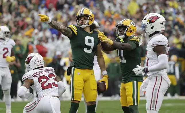 Green Bay Packers wide receiver Christian Watson (9) signals a first down after a reception during the first half of an NFL football game against the Arizona Cardinals, Sunday, Oct. 13, 2024, in Green Bay. (AP Photo/Matt Ludtke)