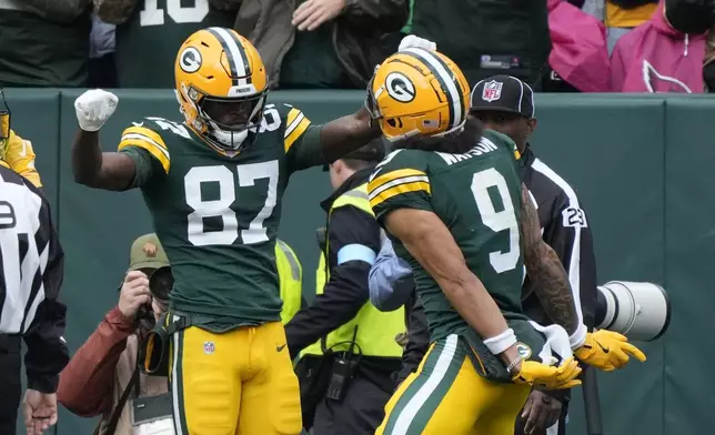 Green Bay Packers wide receiver Romeo Doubs (87) celebrates his 20-yard reception for a touchdown with teammate wide receiver Christian Watson during the second half of an NFL football game against the Arizona Cardinals, Sunday, Oct. 13, 2024, in Green Bay. (AP Photo/Morry Gash)