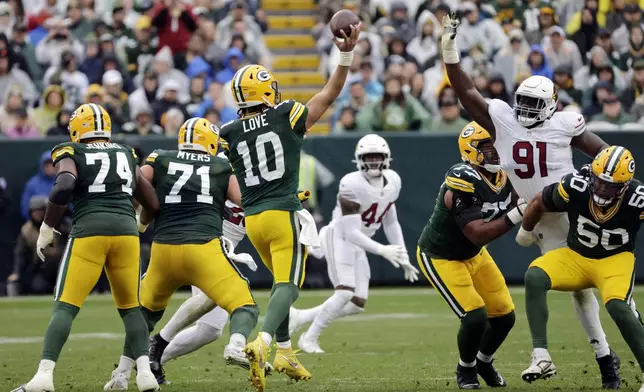 Green Bay Packers quarterback Jordan Love (10) throws over the defense of Arizona Cardinals defensive end L.J. Collier (91) during the first half of an NFL football game, Sunday, Oct. 13, 2024, in Green Bay. (AP Photo/Mike Roemer)