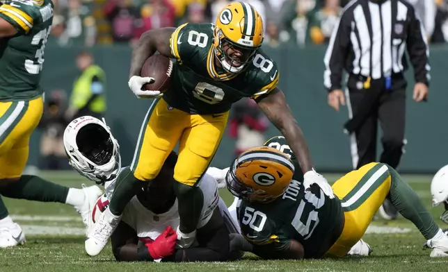 Arizona Cardinals defensive tackle Naquan Jones loses his helmet as he tackles Green Bay Packers running back Josh Jacobs (8) during the second half of an NFL football game, Sunday, Oct. 13, 2024, in Green Bay. (AP Photo/Morry Gash)