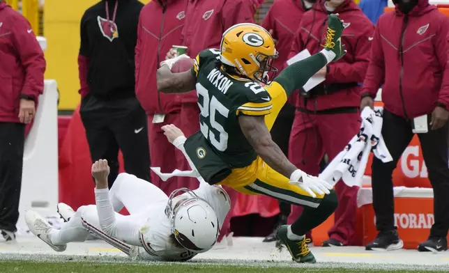 Arizona Cardinals punter Blake Gillikin stops Green Bay Packers cornerback Keisean Nixon (25) on a punt return during the first half of an NFL football game, Sunday, Oct. 13, 2024, in Green Bay. (AP Photo/Morry Gash)