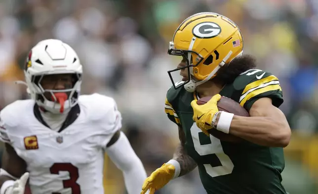 Green Bay Packers wide receiver Christian Watson (9), defended by Arizona Cardinals safety Budda Baker (3), has a 44-yard reception for a touchdown during the first half of an NFL football game, Sunday, Oct. 13, 2024, in Green Bay. (AP Photo/Matt Ludtke)