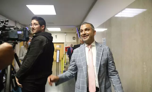 Attorney Saam Zangeneh walks past members of the media in the hallway outside Department 28 at the Hall of Justice on the first day of the trial of Nima Momeni, on the first day of the trial of Nima Momeni, a tech consultant charged in the stabbing death of Cash App founder Bob Lee, Monday, Oct. 14, 2024, in San Francisco. Momeni has pleaded not guilty. (Lea Suzuki/San Francisco Chronicle via AP)