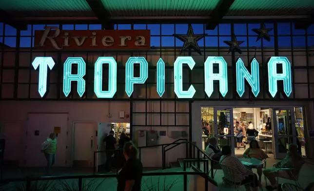 People walk by a sign for the Tropicana on display at the Neon Museum, Wednesday, April 3, 2024, in Las Vegas. (AP Photo/John Locher)