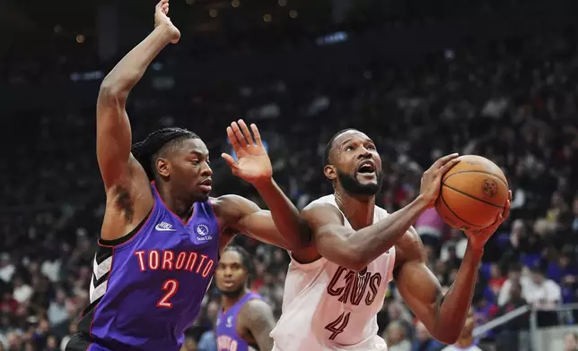 Cleveland Cavaliers' Evan Mobley (4) is fouled by Toronto Raptors' Jonathan Mogbo (2) during the first half of an NBA basketball game, Wednesday, Oct. 23, 2024 in Toronto. (Frank Gunn/The Canadian Press via AP)